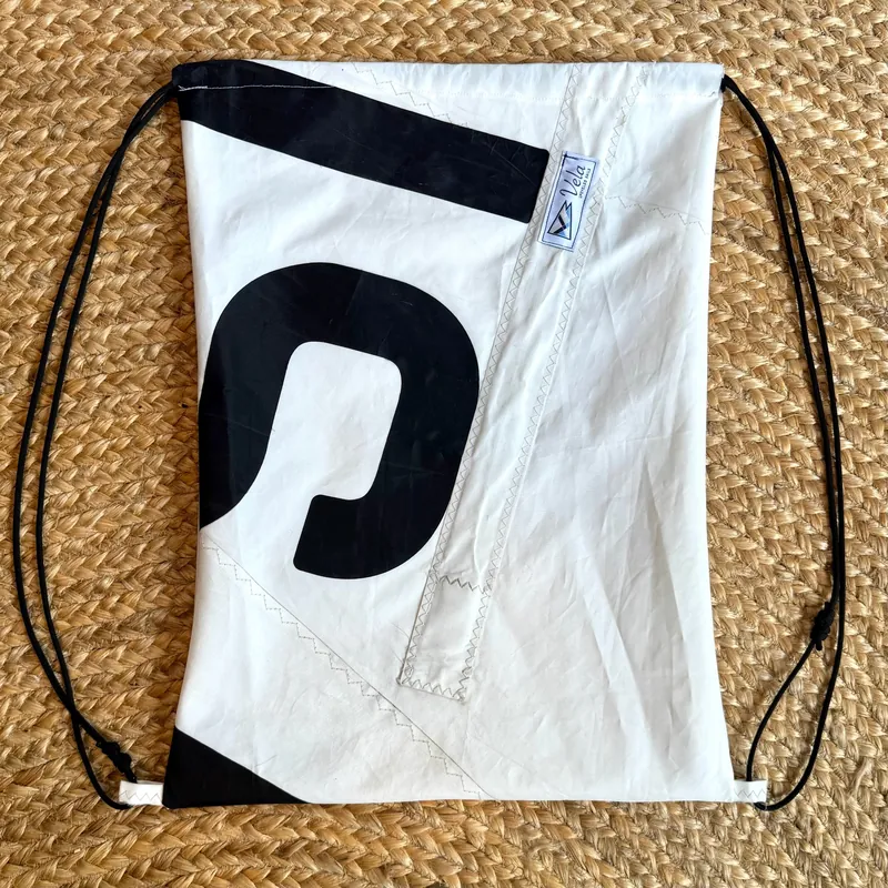 Vela drawstring bag, black sail numeral beside a stitched seam strip