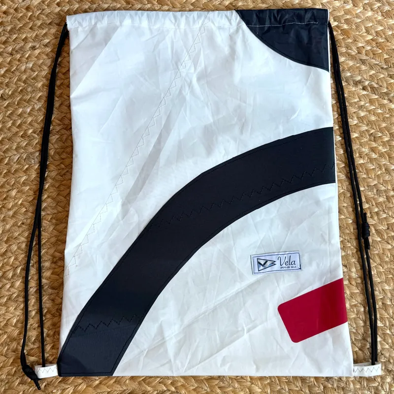 Vela drawstring bag, black arc and red patch on white sailcloth