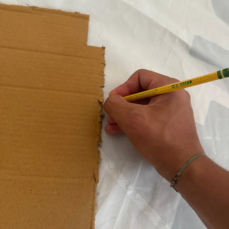 Tracing a bag pattern onto sailcloth with a cardboard template
